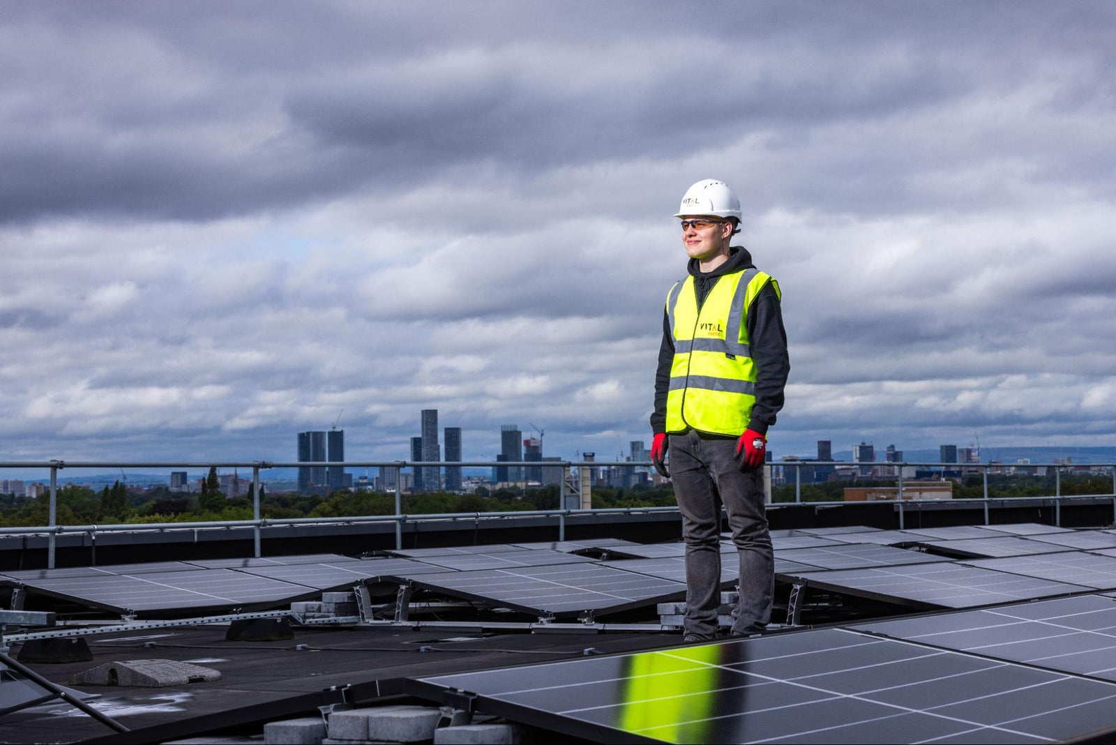 A solar installer standing on a rooftop